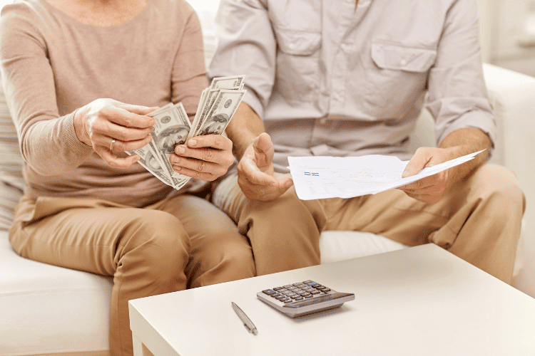 Close-up of a senior couple with money and calculator