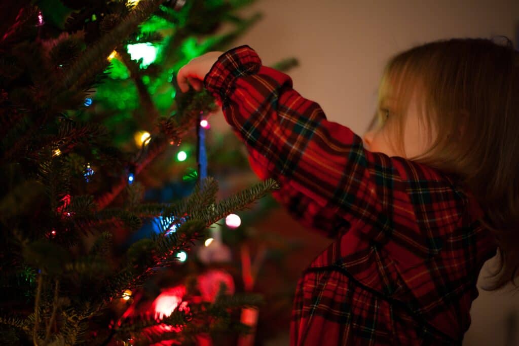 girl hanging a christmas ornament