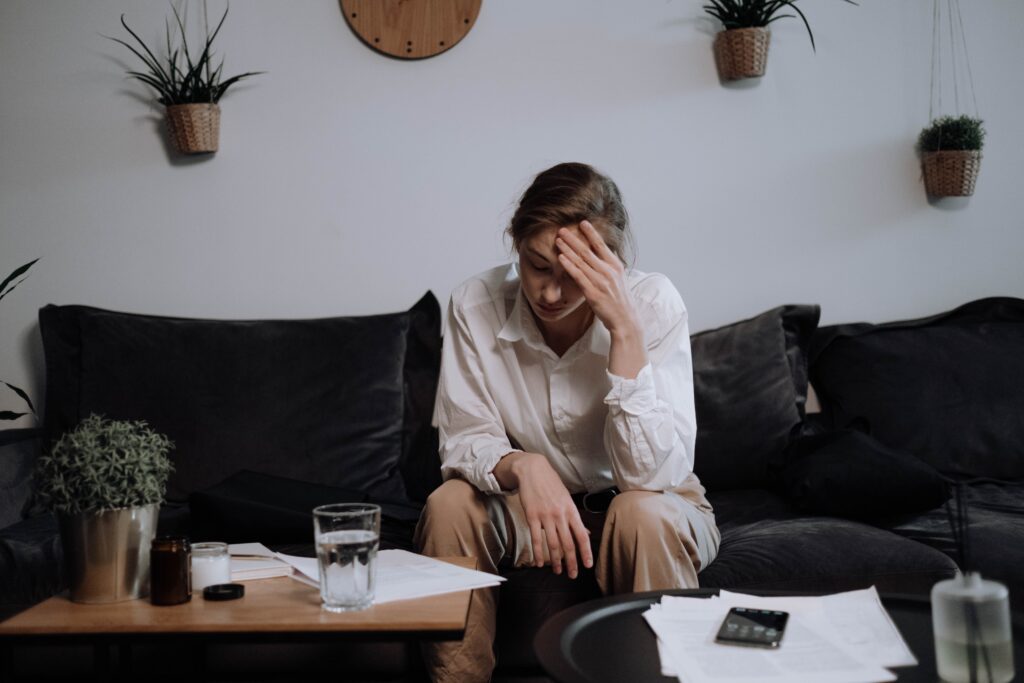 overwhelmed and stressed woman sitting on the couch