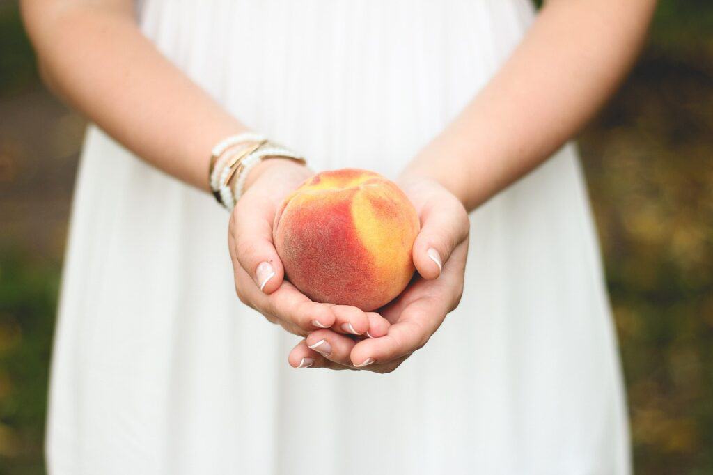 Girl holding a peach